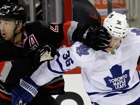 Carolina's Manny Malhotra, left, blocks Toronto's Carl Gunnarsson during NHL action in Raleigh, N.C., Thursday, Jan. 9, 2014. (AP Photo/Gerry Broome)