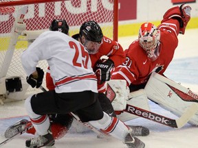 Belle River's Aaron Ekblad, centre, helps Canadian goalie Zachary Fucale makes a save against Switzerland Dario Simion during the world junior quarter-final in Malmo, Sweden, on Thursday, January 2, 2014. (THE CANADIAN PRESS/Frank Gunn)