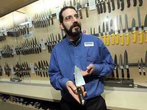 Joel Beneteau holds one of the many knives available at Williams Food Equipment in Windsor. (TYLER BROWNBRIDGE / The Windsor Star)
