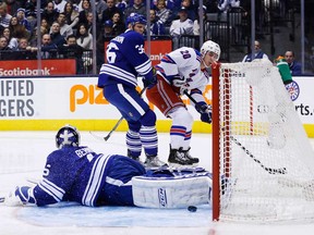 Maple Leafs defenceman Carl Gunnarsson, left, battles New York's Chris Kreider, right,  in Toronto, Saturday January 4, 2014. Gunnarsson was injured in the game. (THE CANADIAN PRESS/Mark Blinch)
