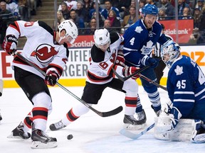 New Jersey's Ryan Carter, left, takes a shot on Maple Leafs goalie Jonathan Bernier, right, as Maple Leafs forward defenceman Cody Franson and Devils forward Steve Bernier battle during the first period in Toronto on Sunday, January 12, 2014. (THE CANADIAN PRESS/Nathan Denette)