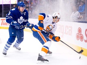 Maple Leafs defenceman Dion Phaneuf, left, checks Islanders forward John Tavares in Toronto on Tuesday, January 7, 2014. (THE CANADIAN PRESS/Nathan Denette)