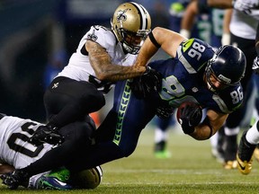 Seattle tight end Zach Miller, right, is tackled by New Orleans safety Kenny Vaccaro December 2, 2013 in Seattle. The Seahawks host the Saints Saturday. (Jonathan Ferrey/Getty Images)