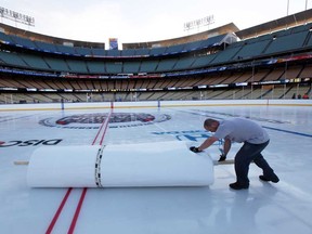 A worker helps clean up the ice at Dodger Stadium in preparation for the 2014 NHL Stadium Series in Los Angeles, Wednesday, Jan. 22, 2014. The Kings and Ducks will play at Dodger Stadium Saturday. (AP Photo/Nick Ut)