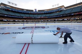 A worker helps clean up the ice at Dodger Stadium in preparation for the 2014 NHL Stadium Series in Los Angeles, Wednesday, Jan. 22, 2014. The Kings and Ducks will play at Dodger Stadium Saturday. (AP Photo/Nick Ut)