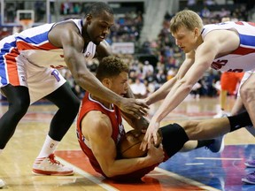 Pistons guard Rodney Stuckey, left, and forward Kyle Singler, right, reach in on Los Angeles Clippers forward Blake Griffin in Auburn Hills, Mich., Monday, Jan. 20, 2014. (AP Photo/Carlos Osorio)