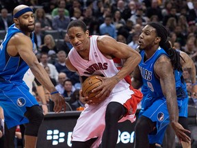 Toronto's DeMar DeRozan, centre, drives past Dallas forwards Vince Carter, left, and Jae Crowder in Toronto on Wednesday, January 22, 2014. (THE CANADIAN PRESS/Nathan Denette)