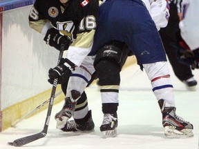 LaSalle's Nathan Veres, left, battles along the boards with the Strathroy's Wes Baker at the Vollmer Centre in LaSalle on Wednesday, January 22, 2013. (TYLER BROWNBRIDGE/The Windsor Star)