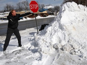 Windsor auto mechanic John Yablonksy adds to a monstrous snow pile on Tecumseh Road East in January 2014. (Nick Brancaccio / Windsor Star files)