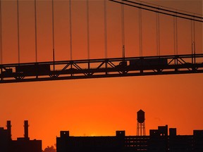 The sun sets near the Ambassador Bridge, Tuesday, Jan. 28, 2014, after a bitterly cold day.