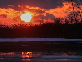 The sun sets near Manning Rd. and county Rd. 34 over a wet field Mon. Jan. 13, 2014.  (DAN JANISSE/The Windsor Star)