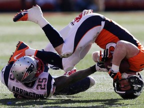 Broncos wide receiver Wes Welker, right, is upended by Patriots cornerback Kyle Arrington in the AFC Championship game in Denver, Sunday, Jan. 19, 2014. (AP Photo/Julie Jacobson)