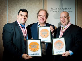 Corby's Lot No. 40 was named Canadian Whisky of the Year at the Canadian Whisky Awards, held Jan.16, 2014, in Victoria, B.C. David Weaver and Bill Atwood, of Corby Distillers, accept their award from Davin de Kergommeaux, centre, chairman of the judges. (Photo courtesty of CNW Group)