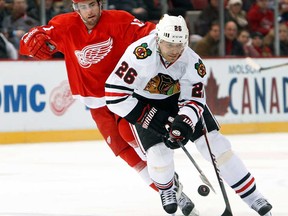 Chicago's Michal Handzus, right, tries to control the puck in front of Detroit's Patrick Eaves Wednesday, Jan. 22, 2014, in Detroit. (AP Photo/Paul Sancya)