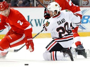Chicago's Brandon Saad, right, loses the puck to Detroit's Brendan Smith Wednesday, Jan. 22, 2014, in Detroit. (AP Photo/Paul Sancya)