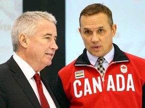 In this file photo, Hockey Canada president and CEO Bob Nicholson, left, speaks to executive director Steve Yzerman during the announcement of the Canadian Men's Olympic Hockey team January 7, 2014 in Toronto. (Abelimages/Getty Images)