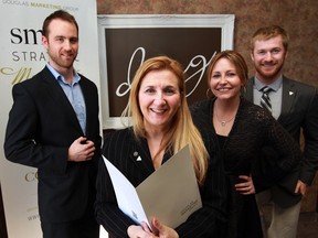 Kay Douglas, centre, of Douglas Marketing is flanked by staffers Paul Schlosser, left, Liz Farano and Brian Small, Friday Feb. 28, 2014.  (NICK BRANCACCIO/The Windsor Star)