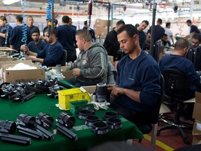 Palestinians work at a SodaStream factory on January 30, 2014 in the Mishor Adumim industrial park,near the West Bank settlement of Maale Adumim.SodaStream,which manufactures a device for making carbonated drinks at home,has 25 factories around the world and employs 800 Palestinians and 500 Israelis at the Mishor Adumim plant, according to a company spokesman. (MENAHEM KAHANA/AFP/Getty Images)