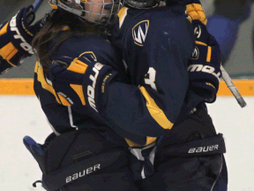 Windsor's Candice Chevalier, left, and Ally Strickland celebrate a goal against Queen's last year at South Windsor Arena. (DAN JANISSE/The Windsor Star)