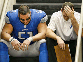 Detroit's Dominic Raiola, left, sits on the steps after the Lions lost in ove time to the New York Giants at Ford Field. (Photo by Leon Halip/Getty Images)