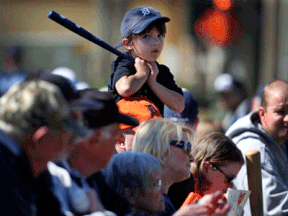 Five-year-old Tyler Robertson of Traverse City sits on his father Jim's shoulders as they wait for the Detroit Tigers on the first day of spring training for pitchers and catchers Friday in Lakeland, Fla. (AP Photo/Gene J. Puskar)
