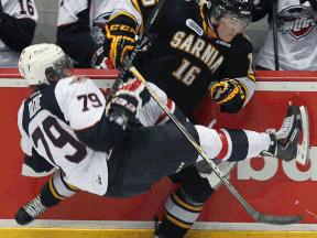Windsor's Ty Bilcke, left, is checked by Sarnia's Davis Brown at the WFCU Centre. (TYLER BROWNBRIDGE/The Windsor Star)