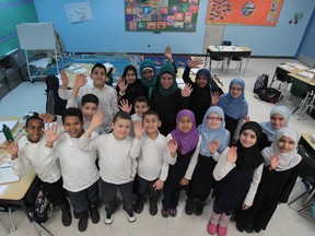 Louay El-Chami, a teacher at  An-Noor Private School in Windsor, is all smiles on Monday, Feb. 3, 2014, along with Grade 4 students who wrote the EQAO testing last year that helped earn the school top honours in the  top-ranking in Ontario in the Fraser Institute's report card on school performance. (JASON KRYK/The Windsor Star)