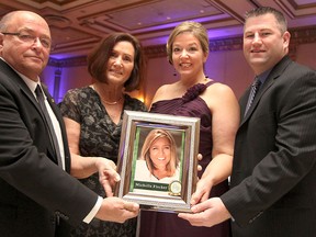 Larry Bertrand, left, Diana Bertrand, Amy Williams and Mitchel Williams hold up a photo of their late daughter and sister, Michelle Fischer, at the 16th annual In Honour of the Ones We Love gala held at the Ciociaro Club on Saturday, February 8, 2014. Fischer was one of this year's four honourees. (REBECCA WRIGHT/ The Windsor Star)