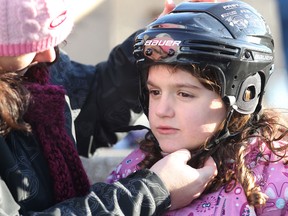 Although the cycling helmet proved to be best to protect children from high-velocity impacts common to tobogganing, the hockey helmet is a parent's safest and most practical bet. In this file photo, Rhyen Waspe of Windsor, is getting a helmet adjusted by Laura Kay of the Brain Injury Association. (Dan Janisse / Windsor Star)