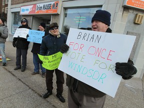 Travis Barron (far left) leads a small group of protesters in front of the office of Windsor-West MP Brian Masse in Windsor on Wednesday, February 26, 2014. The group Vote With Windsor is urging Masse to support the federal budget.                 (TYLER BROWNBRIDGE/The Windsor Star)