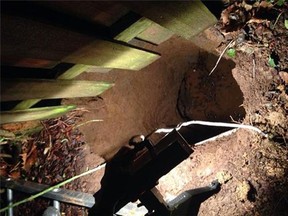 This image provided by the Portland Oregon Fire & Rescue shows the sinkhole where a woman was rescued unharmed after falling into the six-metre-deep sinkhole that opened up in her backyard Tuesday night Feb. 18, 2014.  (AP Photo/Portland Oregon Fire & Rescue)