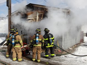 Windsor firefighters at the scene of a garage fire at 1107 Hall Ave., Wednesday February 26, 2014. Firefighters quickly had the flames out, but thick smoke clouded the neighbourhood. (NICK BRANCACCIO/The Windsor Star).