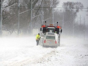 In this file photo, a tow truck driver works to free a stuck vehicle on Riverside Drive near Sandpoint Beach in Windsor on Thursday, January 2, 2014.                       (TYLER BROWNBRIDGE/The Windsor Star)