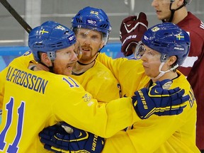 Sweden forward Daniel Alfredsson. left, celebrates his goal against Latvia teammates Daniel Sedin, centre, and Nicklas Backstrom, during the 2014 Winter Olympics men's ice hockey game at Shayba Arena Saturday, Feb. 15, 2014, in Sochi, Russia. (AP Photo/Matt Slocum)