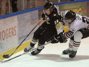 LaSalle's Mark Manchurek, left, is checked by Sarnia's Billy Grillo Wednesday at the Vollmer Centre. (DAN JANISSE/The Windsor Star)