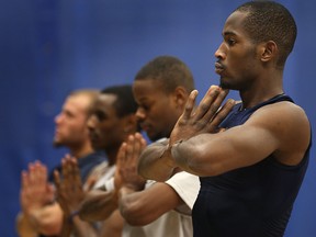 University of Windsor's Lien Phillip, right, and his teammates practise yoga at the St. Denis Centre. (DAN JANISSE/The Windsor Star)