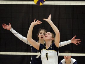 University of Windsor's Emily McCloskey, front, sets the ball in front of  Tracy Hammerton of Nipissing Saturday in OUA volleyball action. (NICK BRANCACCIO/The Windsor Star)