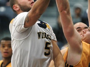 Windsor's Enrico Diloreto, left, drives the lane for a layup against the Waterloo Warriors at the St. Denis Centre. (DAX MELMER/The Windsor Star)