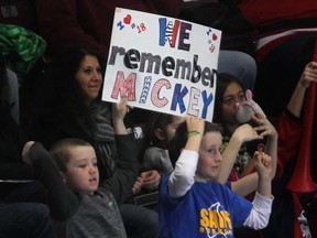 Two young fans hold up a sign in honour of Mickey Renaud Tuesday, Feb. 18, 2014, at the WFCU Centre in Windsor. against London. The club marked the sixth anniversary of the former captain's death. (DAN JANISSE/The Windsor Star)