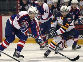 Windsor's Slater Koekkoek, left, and Barrie's Cordell James battle for the puck Thursday, Feb. 27, 2014, during OHL action at the WFCU Centre in Windsor. The Spits won 4-1. (DAN JANISSE/The Windsor Star)