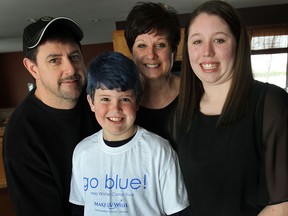 Nicholas Lavin, 10, is a cancer  survivor who has dyed his hair blue to raise money for the Go Blue Go Bald head shave event Feb. 27 in Windsor for Make A Wish Southwestern Ontario. He shown, Thursday, Feb. 20, 2014, with his father Dave Lavin, mother Jennifer Lavin and sister Jylliane Lavin at their Lakeshore, Ont. home. (DAN JANISSE/The Windsor Star)