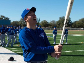 Toronto Blue Jays pitcher Tomo Ohka laughs while swinging a bat during spring training Tuesday, Feb. 18, 2014, in Dunedin, Fla. (AP Photo/The Canadian Press, Frank Gunn)