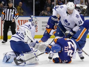 Toronto's Paul Ranger, top, checks New York's Anders Lee in front of Leafs goalie Jonathan Bernier Thursday, Feb. 27, 2014, in Uniondale, N.Y. The Leafs lost 5-4 in OT. (AP Photo/Frank Franklin II)