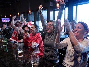 Devon Truax,  Donna Stickles,  Liliana Lopez, Blaire Kniaziew Gervais, Rick Gori, Jeff Tellier, Darren Stubbart, and Derek Leslie  celebrate team Canada's winning goal at Jose's Bar and Grill in Leamington, Ontario on February 20, 2014. Team Canada defeated the United States to gold in Women's hockey. (JASON KRYK/The Windsor Star)
