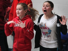 Grace Johnson, left, and Carly Kelly cheer on their teammates during an Olympic themed event Fri. Feb. 7, 2014, at the First Lutheran Christian Academy in Windsor, Ont. The students competed in an variety of fitness challenges to celebrate the kick-off of the Olympic games.  (DAN JANISSE/The Windsor Star