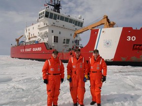 Members of the United States Coast Guard stand in front of the USCGC Mackinaw in this handout photo. (HANDOUT/U.S. Coast Guard)