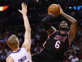 Detroit's Kyle Singler, left, tries to block Miami's LeBron James during NBA action in Miami, Monday, Feb. 3, 2014. (AP Photo/Pat Carter)