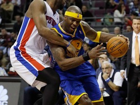 Detroit's Andre Drummond, left, reaches in and fouls Golden State's Jermaine O'Neal in Auburn Hills, Mich., Monday, Feb. 24, 2014. (AP Photo/Carlos Osorio)