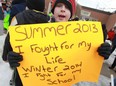 Aiden Pitre, 9, joins dozens of fellow students, parents, and members of the community to rally against the possible closing of St. Maria Goretti Catholic School,  Friday, Feb. 21, 2014.  Pitre's sign, 'Summer 2013 I fought for my life, Winter 2014 I fight for my School' refers to his battle with appendicitis the previous summer.  (DAX MELMER/The Windsor Star)