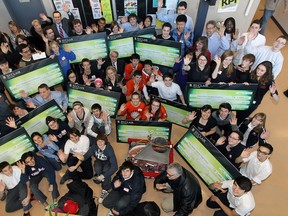 Members from 13 local high school robotics teams gather around St. Clair College president John Strasser, centre of the row second from the top, on Feb. 13, 2014. Each team received $1,000 from the college. (TYLER BROWNBRIDGE/The Windsor Star)